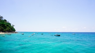 A vibrant coastal scene in Krabi with turquoise waters and local boats near the shore