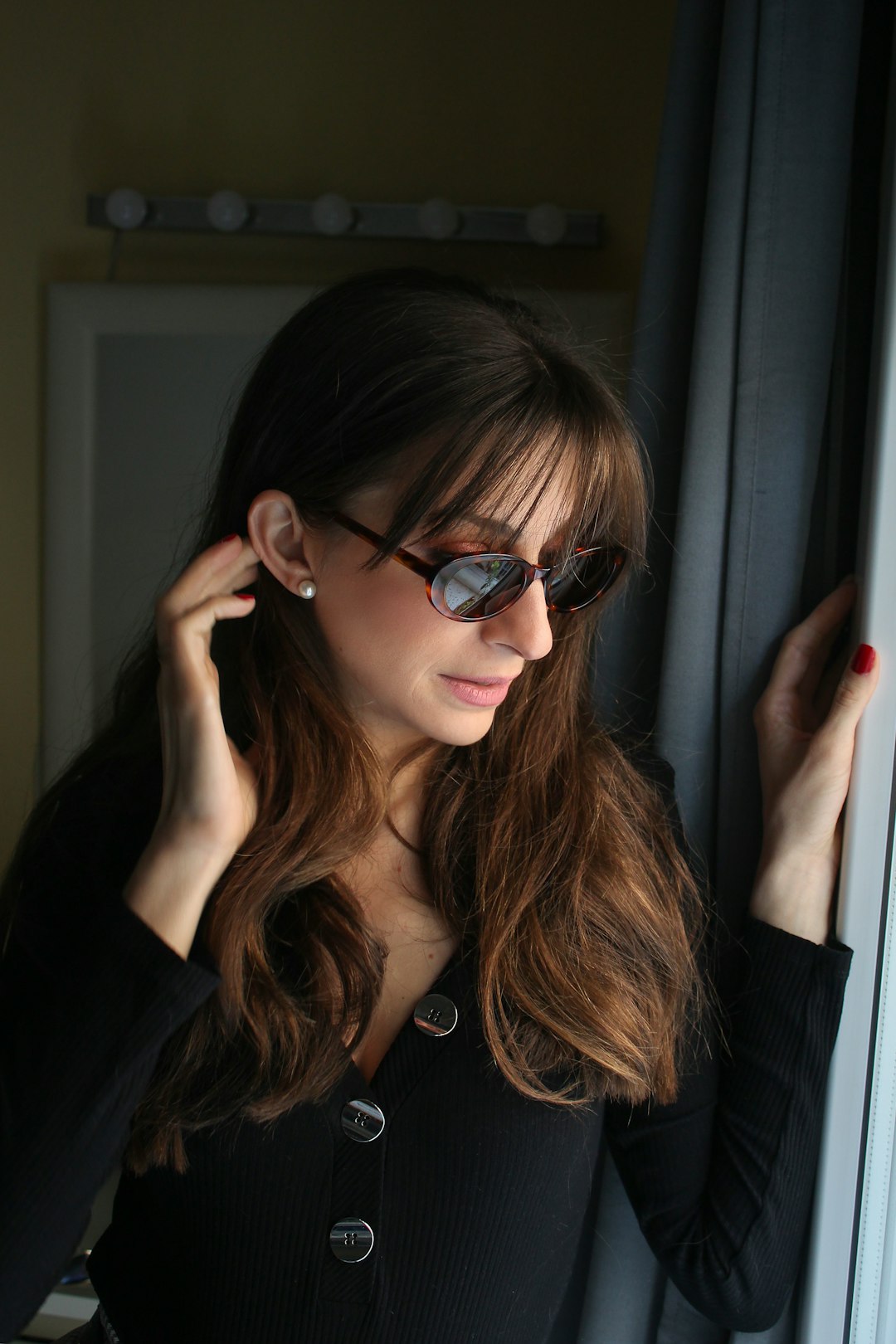 woman wearing sunglasses holding wall