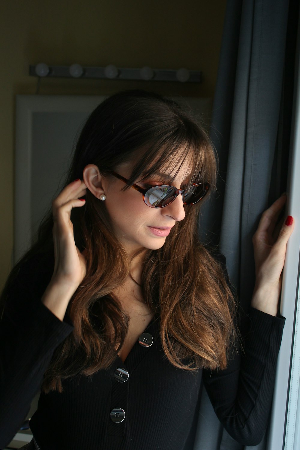 Mujer con gafas de sol sosteniendo la pared