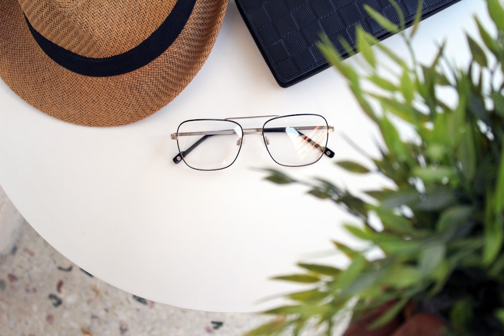 flat lay photography of sunglasses beside sun hat on table