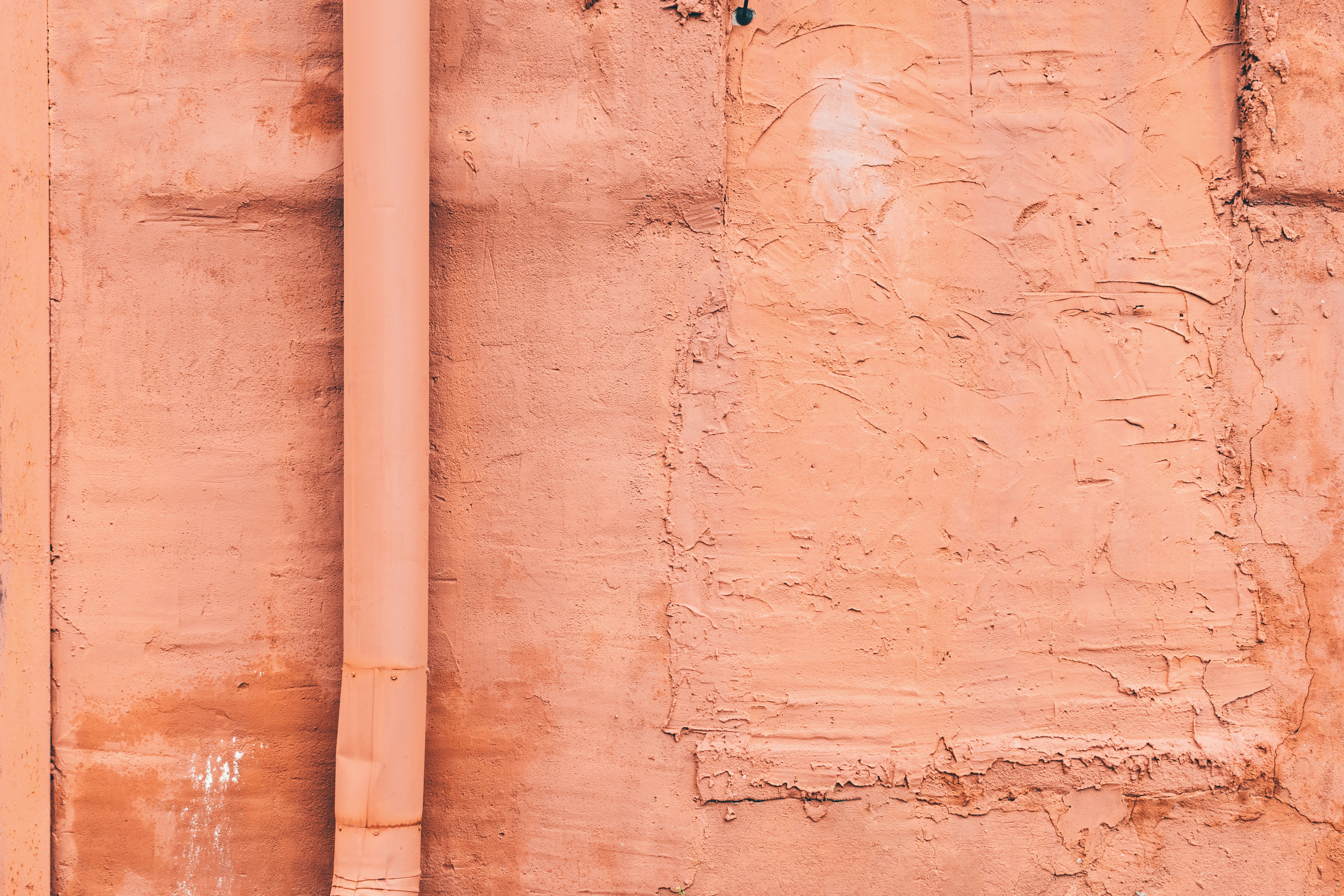 a red fire hydrant sitting next to a pink wall