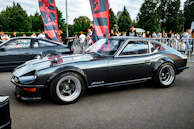 Classic vintage car in pristine condition displayed at an outdoor car event.