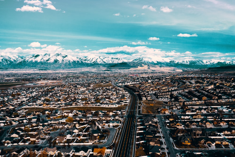 an aerial view of a city with mountains in the background