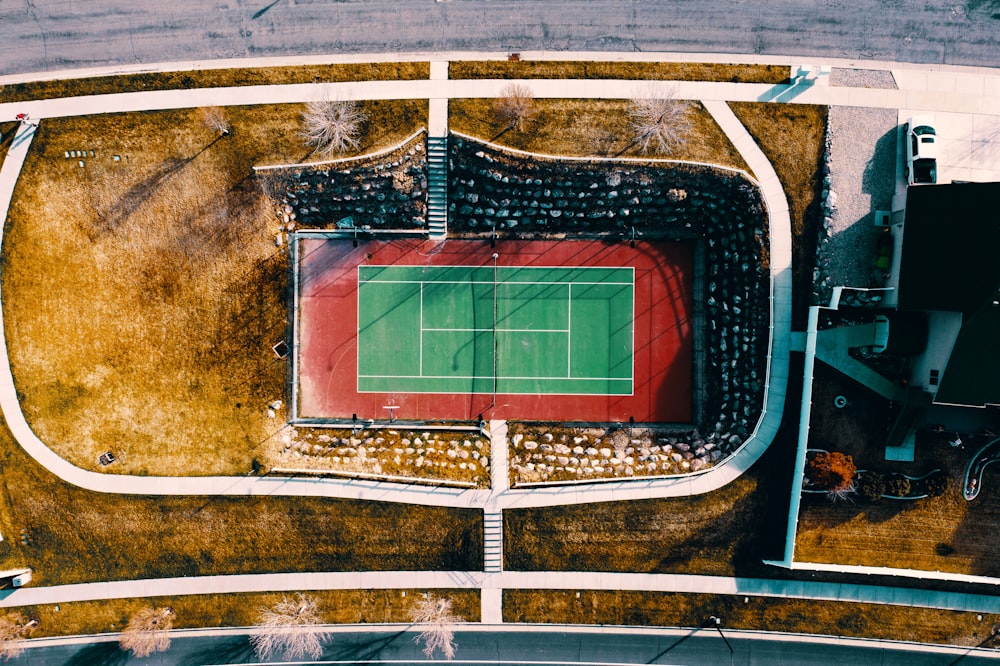 an aerial view of a tennis court in a park