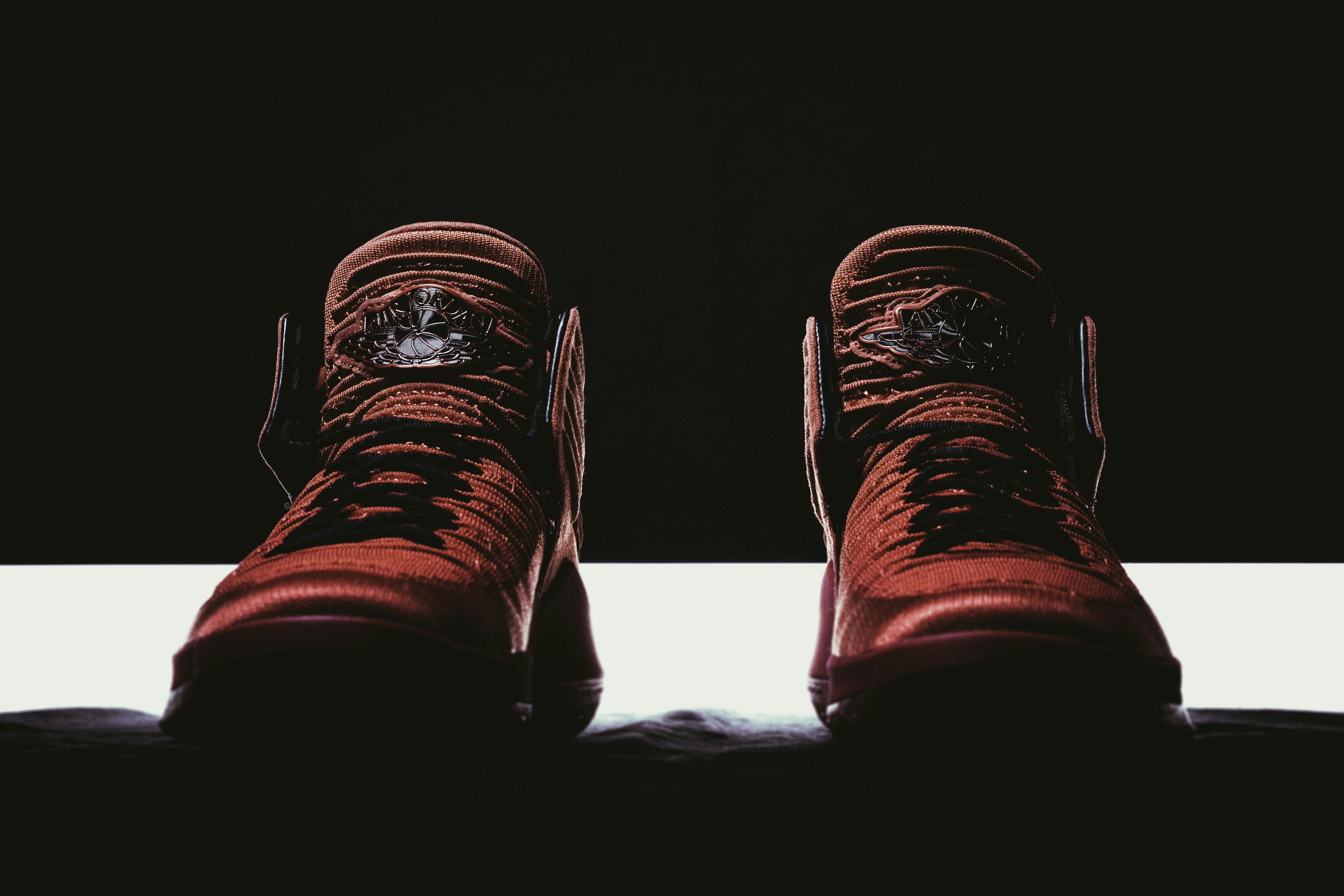 Sports shoes on dark moody background with dramatic shadows and deep atmospheric lighting
