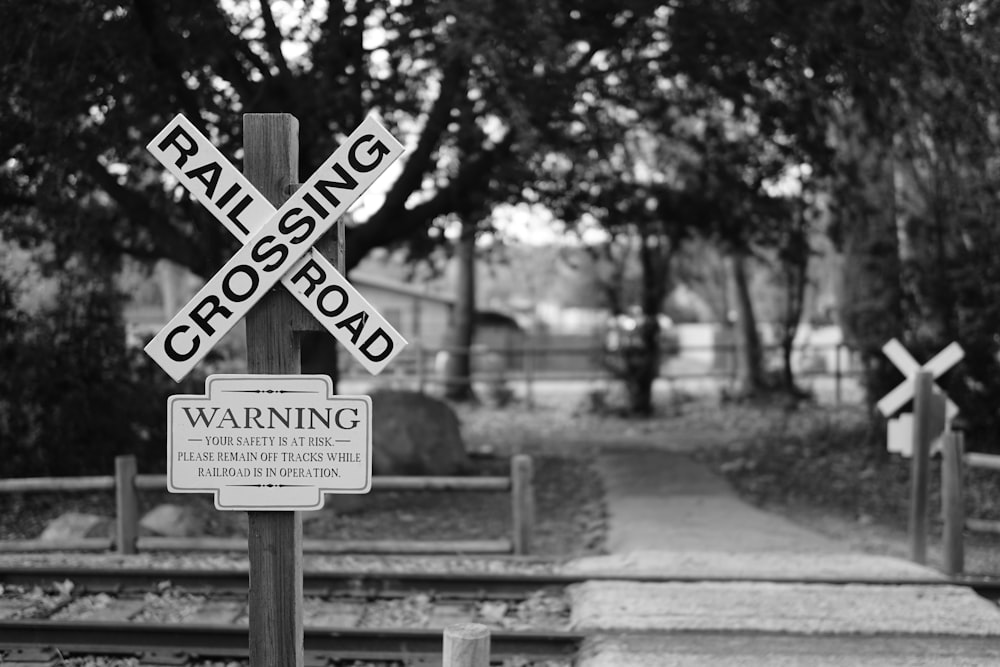grayscale photography of signage near trees