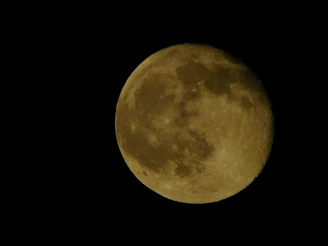 Close-up of the moon’s craters glowing softly against a deep black sky.
