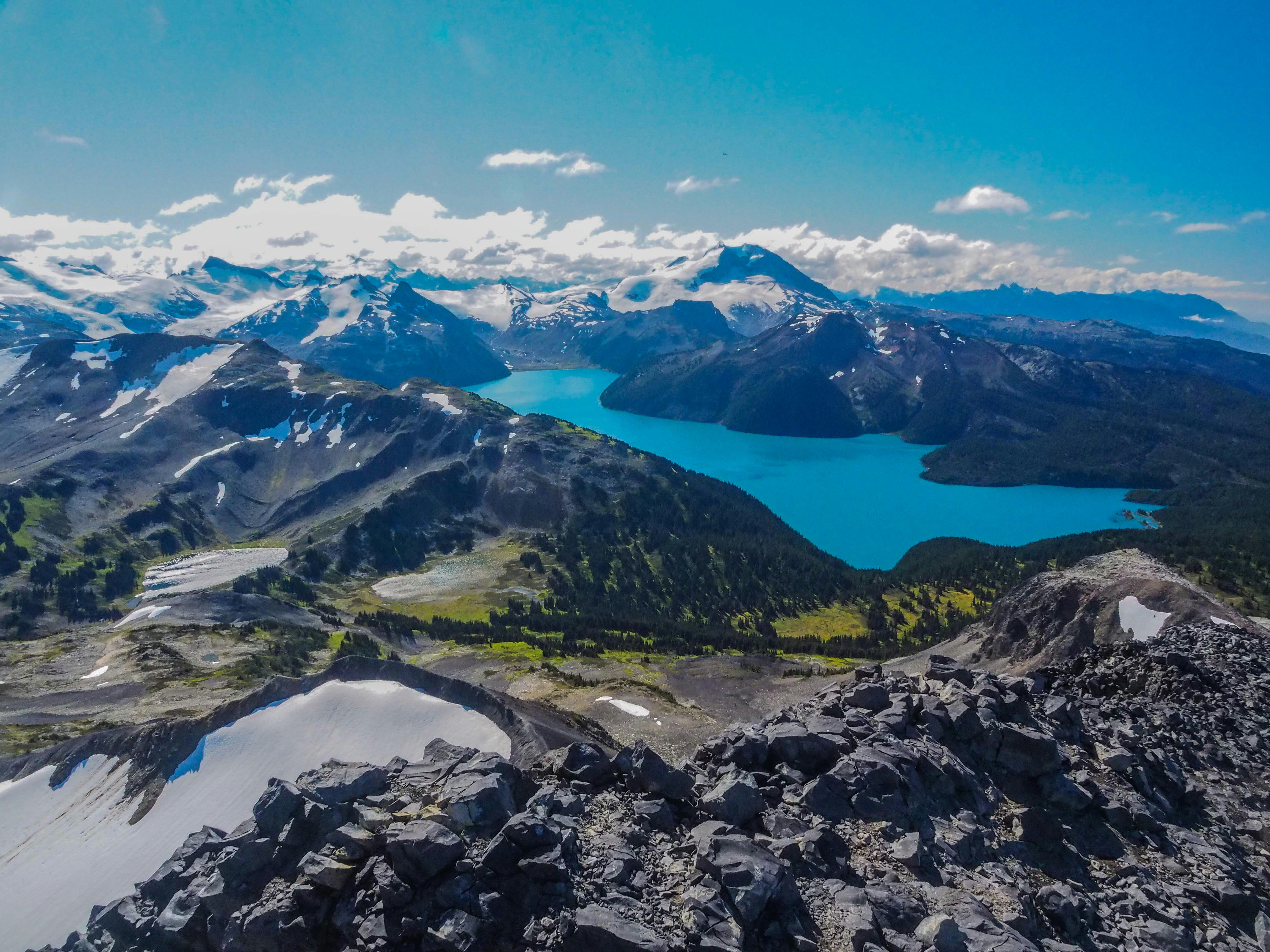 blue body of water between mountain during daytime