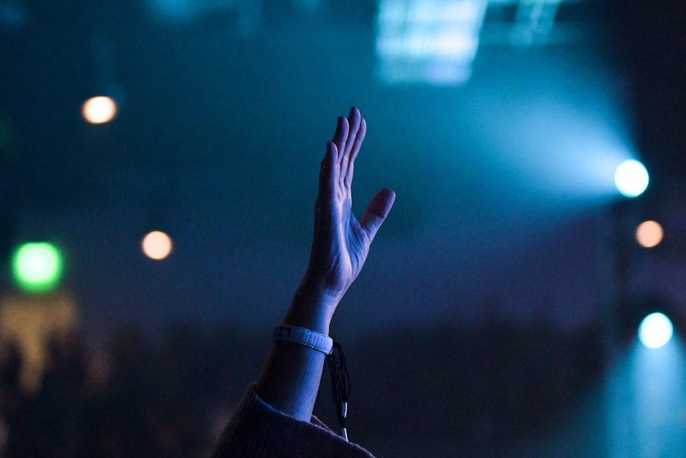 person wearing white band while raising hand