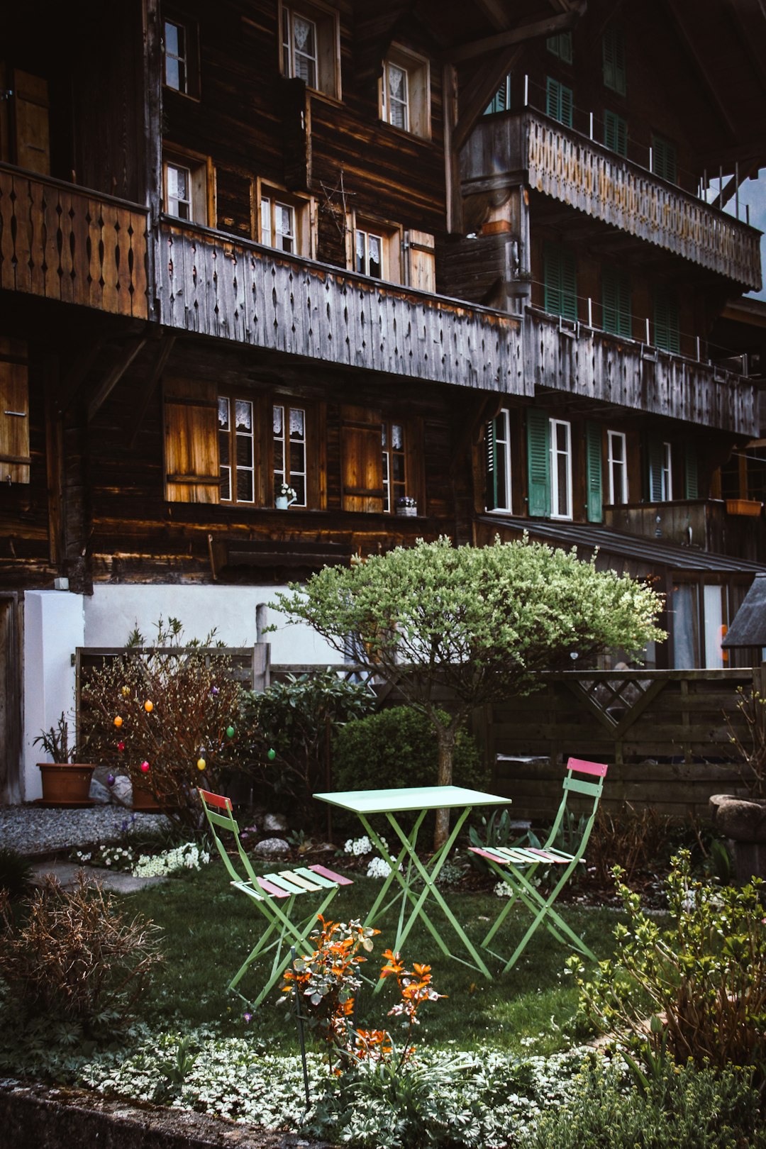 green wooden bistro set beside brown house