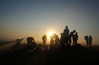 A group of trekkers setting up camp near Mount Rinjani’s crater rim at sunset.