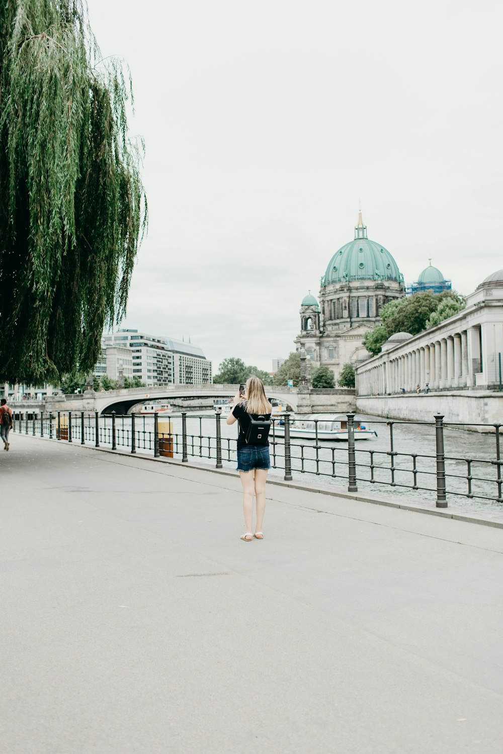 woman standing on concrete pathway near railings viewing dome building