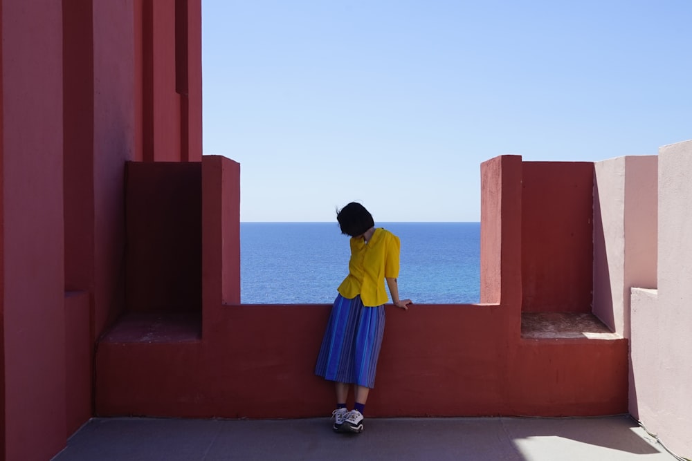 woman leaning by concrete wall