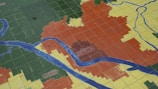 A tiled floor map features different colored sections with blue lines representing rivers or roads. The colorful sections are labeled with names, including 'SEVILLA' and 'CAMAS'.