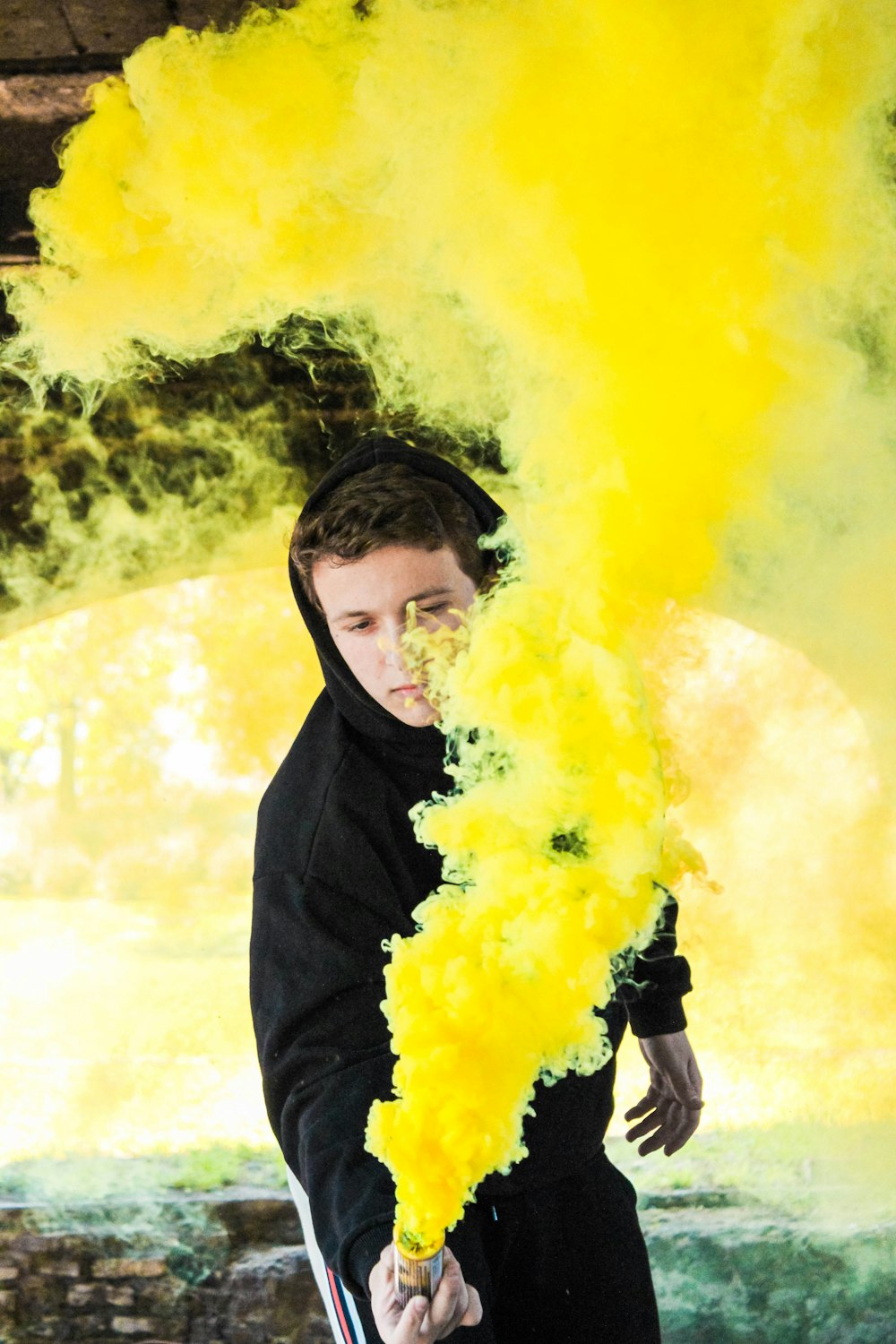 man holding yellow smoke bomb