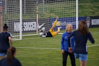 Action shot of a goalkeeper making a save during a competitive game.