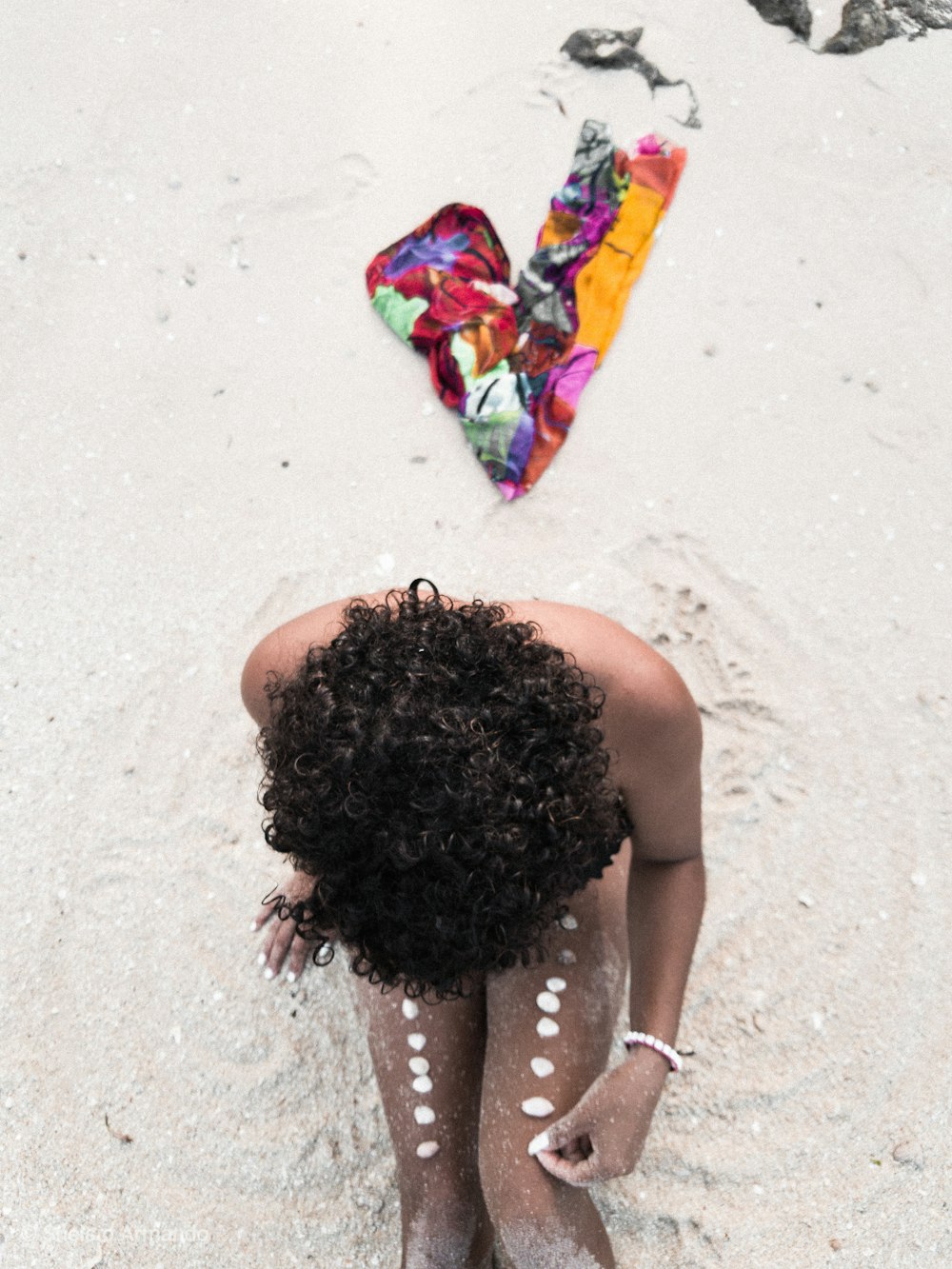 woman sitting on the white sand