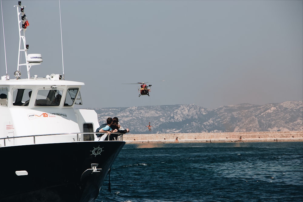 chopper flying over the ship during daytime