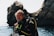 A happy customer wearing a wetsuit while diving in clear ocean waters.