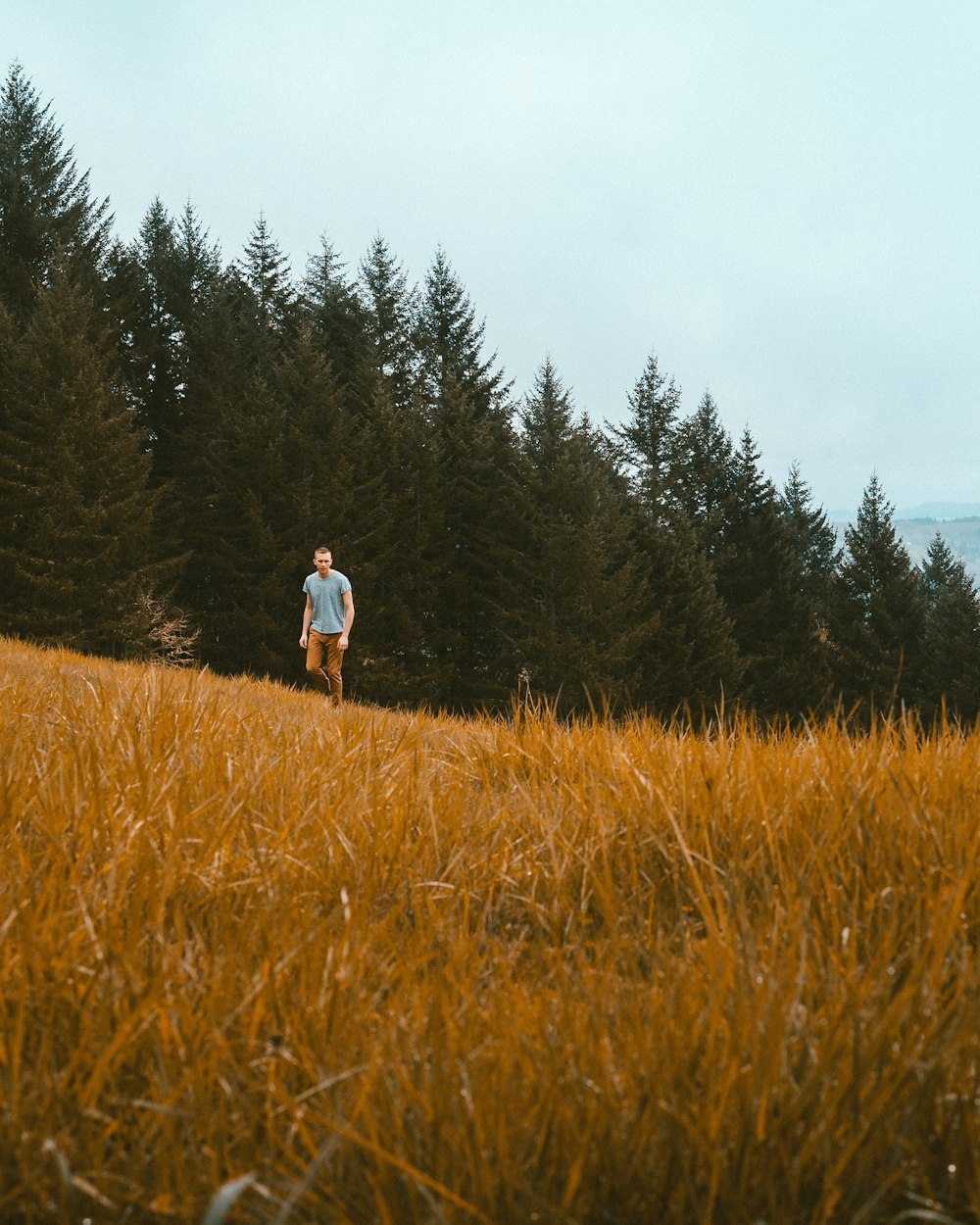 man standing on brown grass field