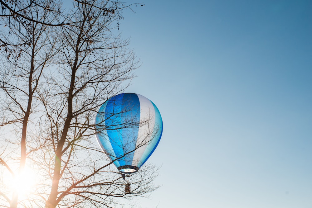 Balão de ar quente azul e branco voando no céu