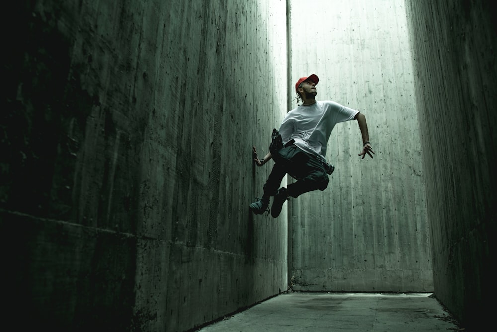 man in white shirt jumping on wall