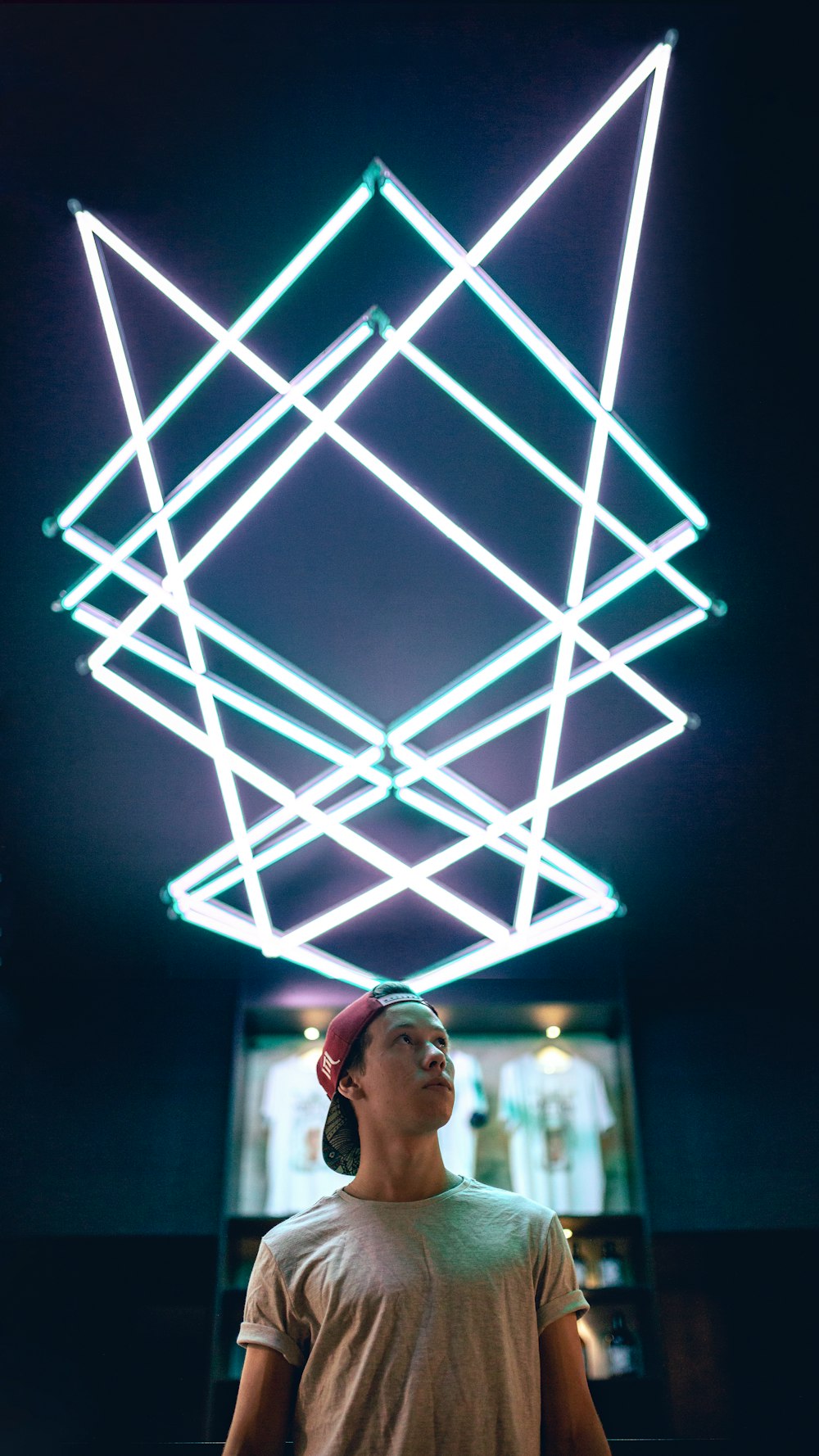um homem parado em frente a um cubo de néon