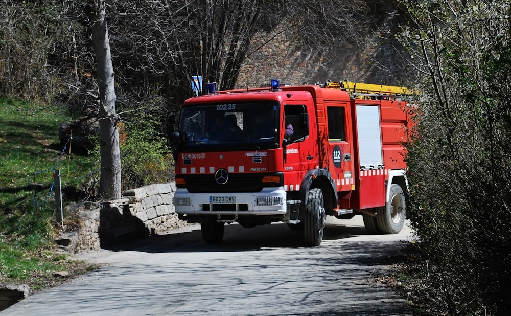 firetruck beside green trees during daytime