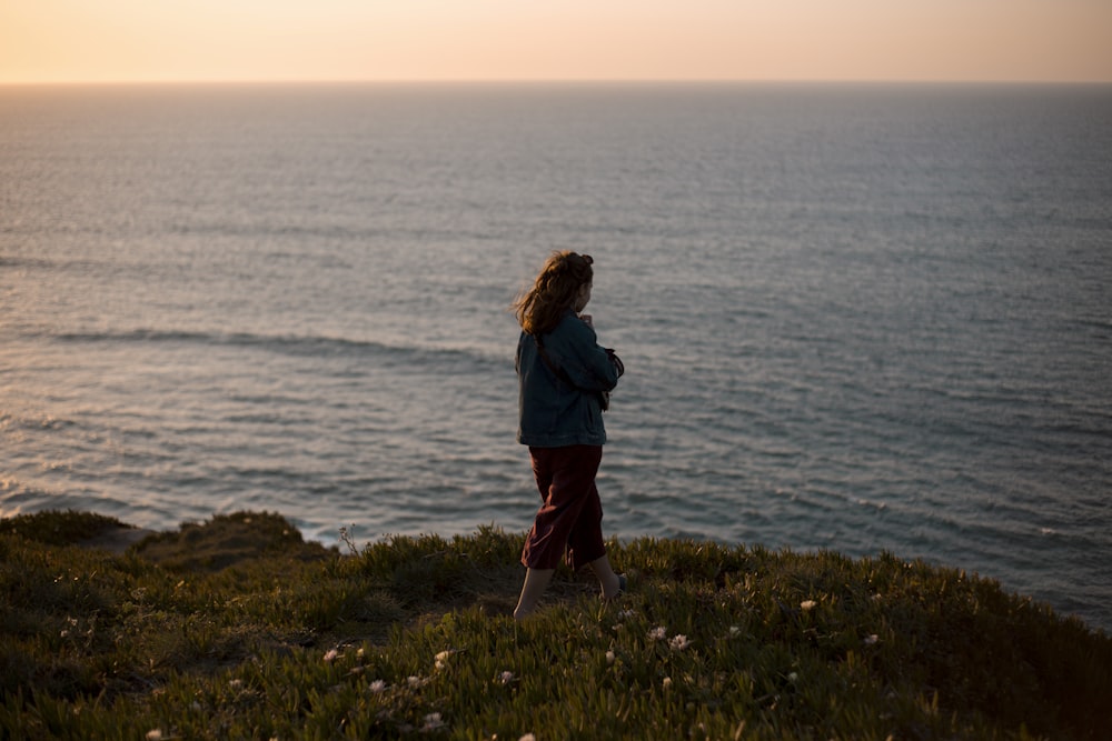 woman standing near edge of mountain