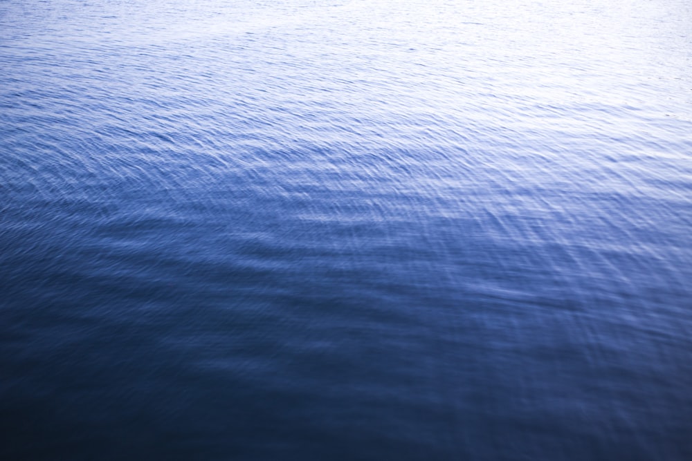 a large body of water with a boat in the distance