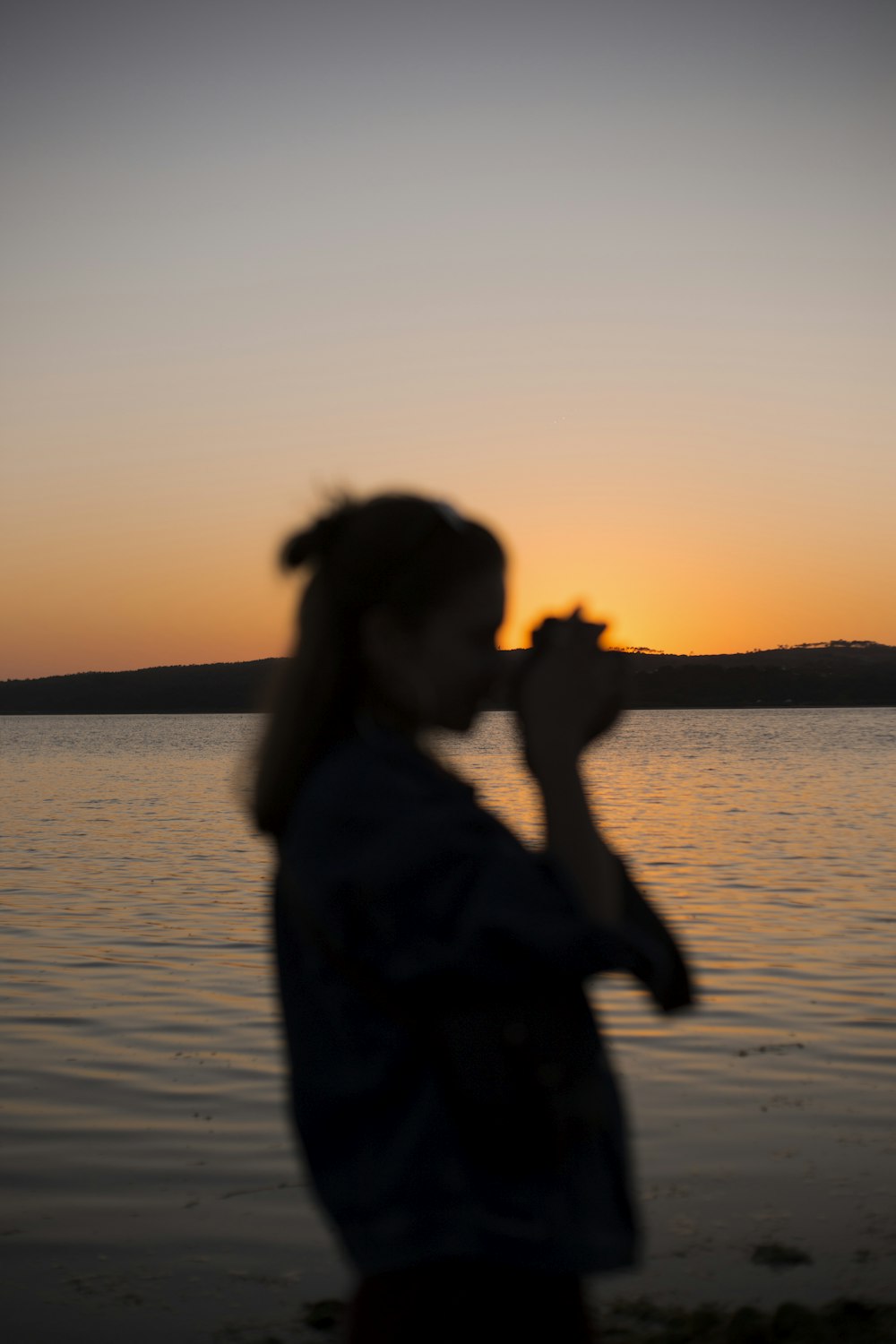 silhouette of woman near body of water