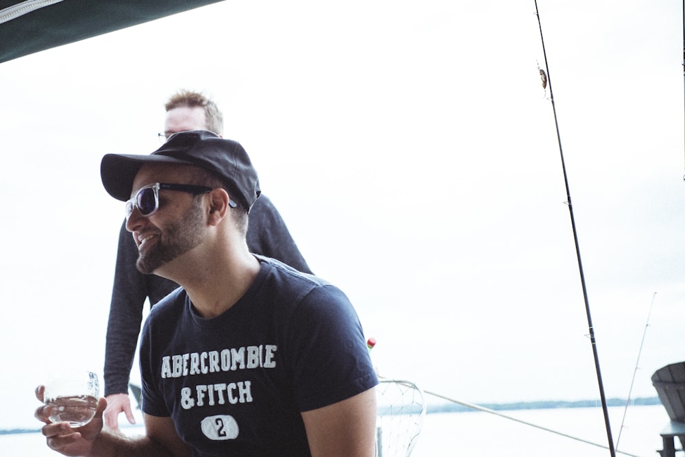 man wearing black Abercrombie & Ftich crew-neck t-shirt holding wine glass