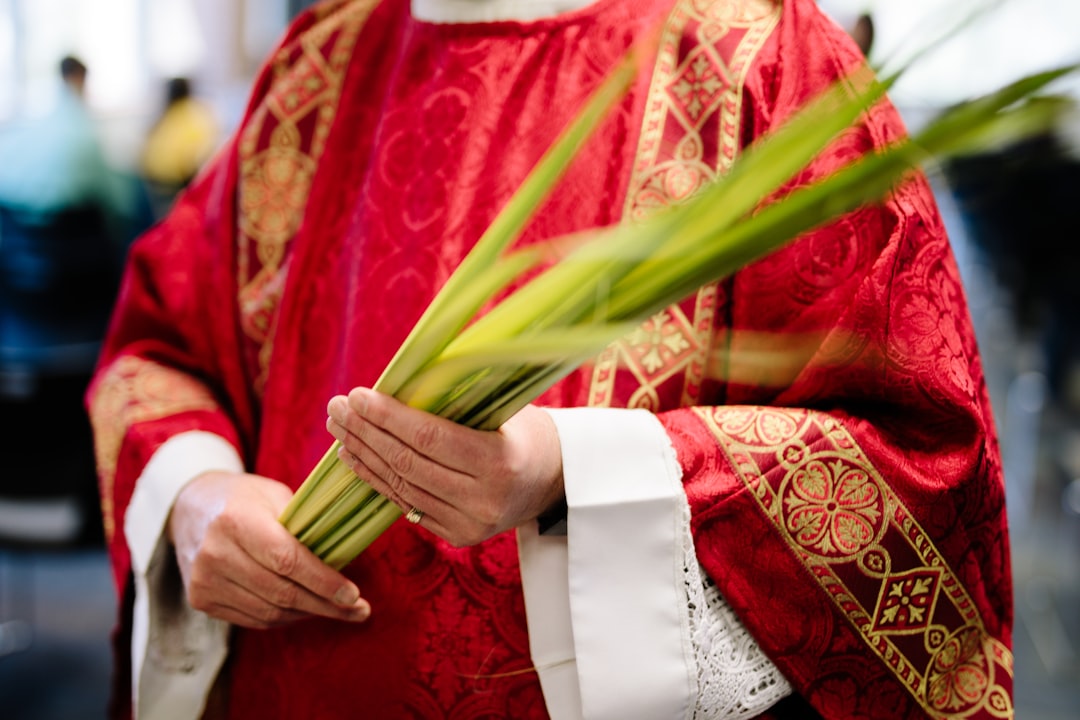Catholic Priest holding palm fronds on Palm Sunday.