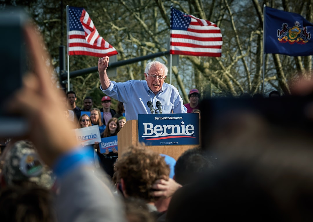 man standing on lectern surrounded by people, Bernie Sanders, Rally at Pittsburgh University, Sunday April 14.