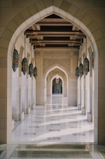 a hallway in a building with columns and arches
