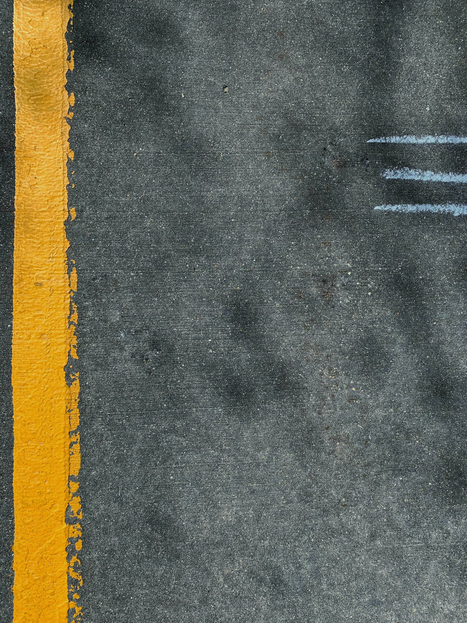 a yellow line painted on the side of a road