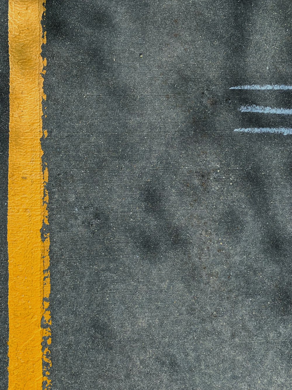 a yellow line painted on the side of a road