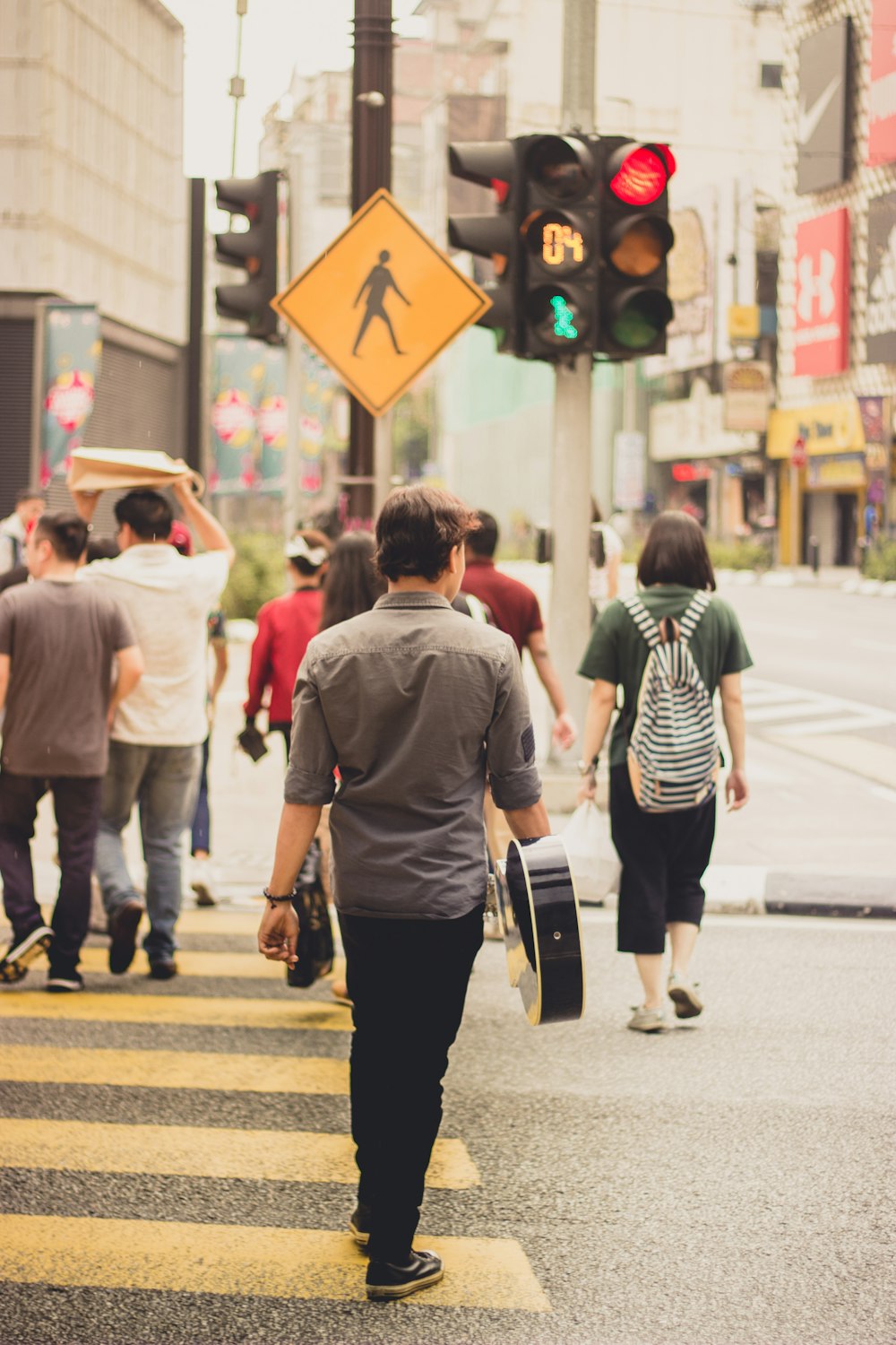 man wearing gray dress shirt standing near traffic light