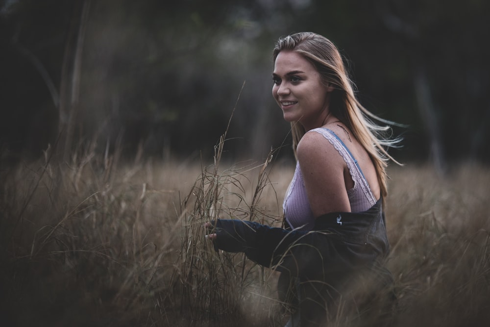 smiling woman standing on brown grass