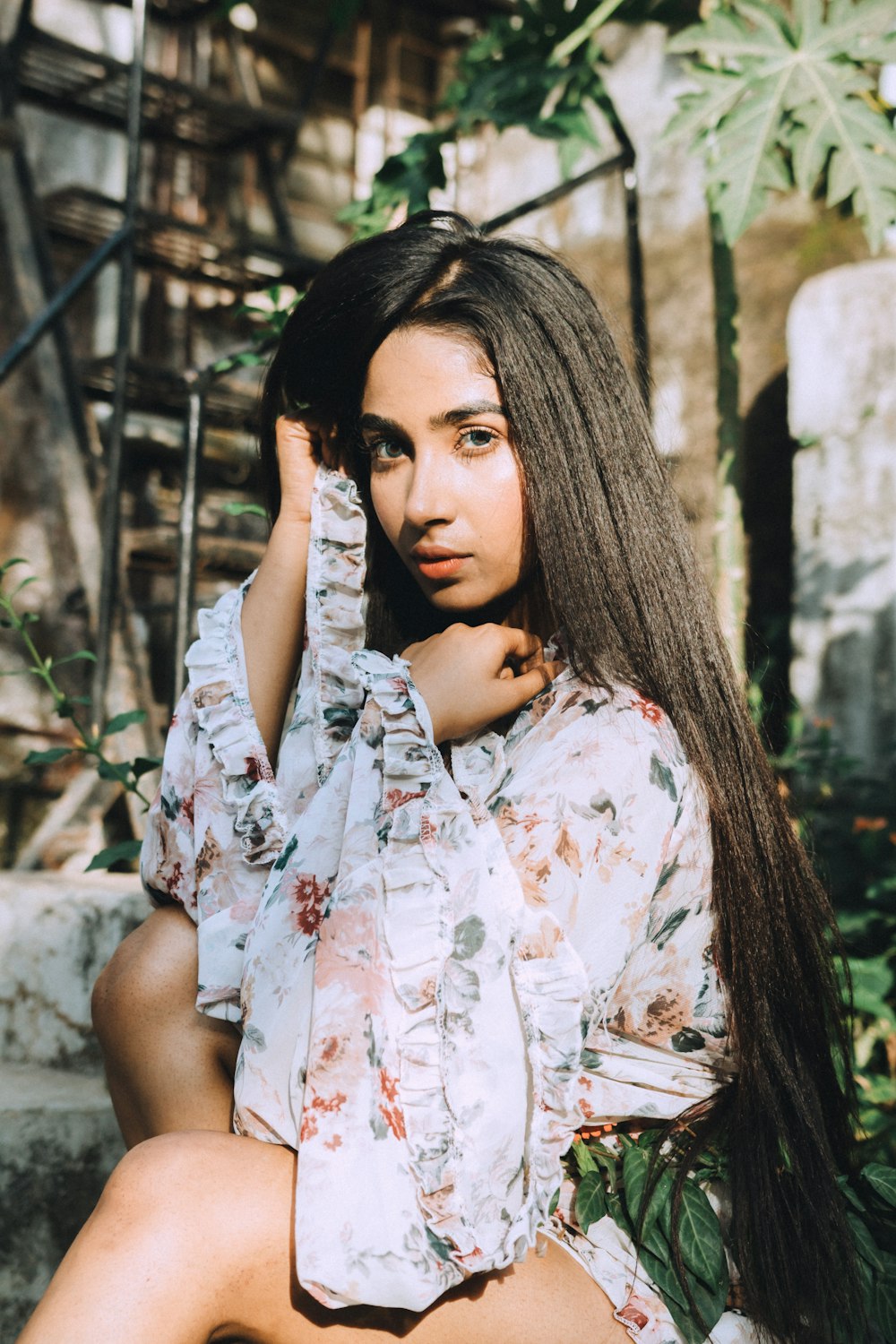 a woman with long hair sitting on steps