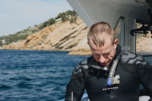 Calvin preparing his scuba gear on a sunny beach before a dive.
