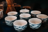 Collection of small ceramic bowls arranged on a wooden table.
