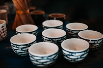 Collection of small ceramic bowls arranged on a wooden table.