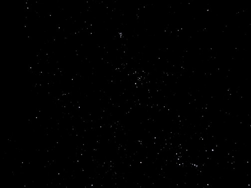 A densely populated night sky filled with numerous stars against a black backdrop, conveying a sense of vastness and mystery.