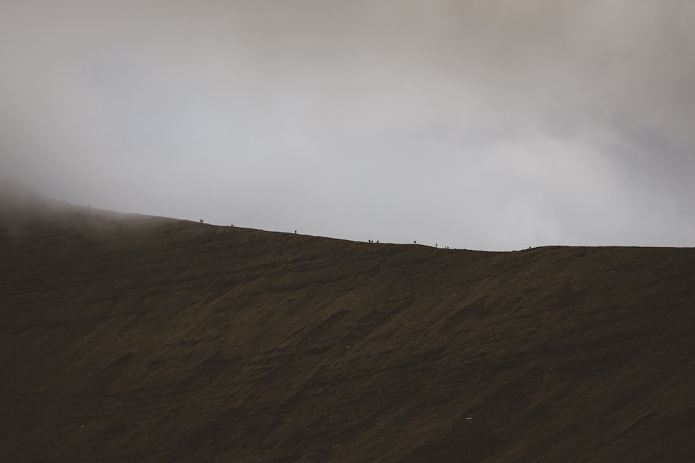 a lone person standing on top of a hill