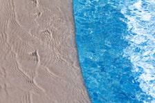 Direct sandy beach access with footprints leading to the water’s edge.