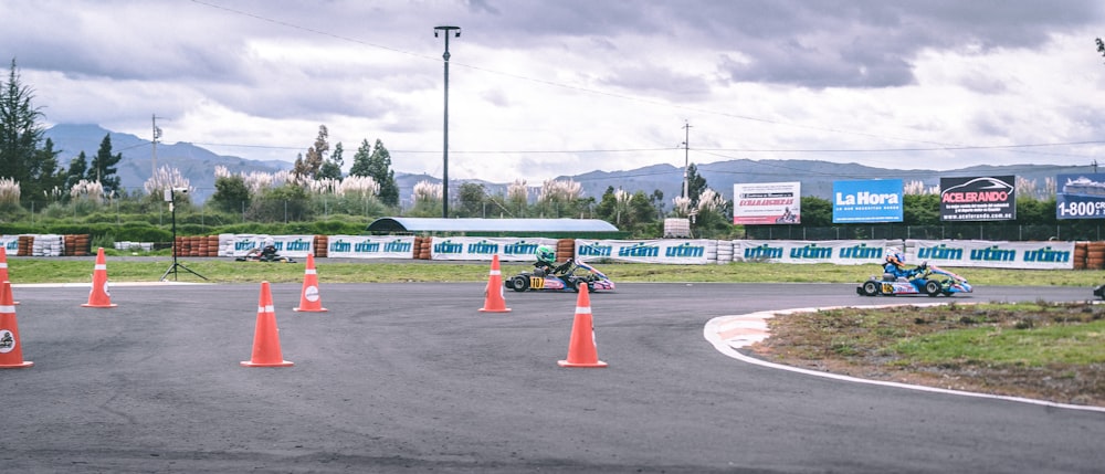 two go-karts racing on track during daytime