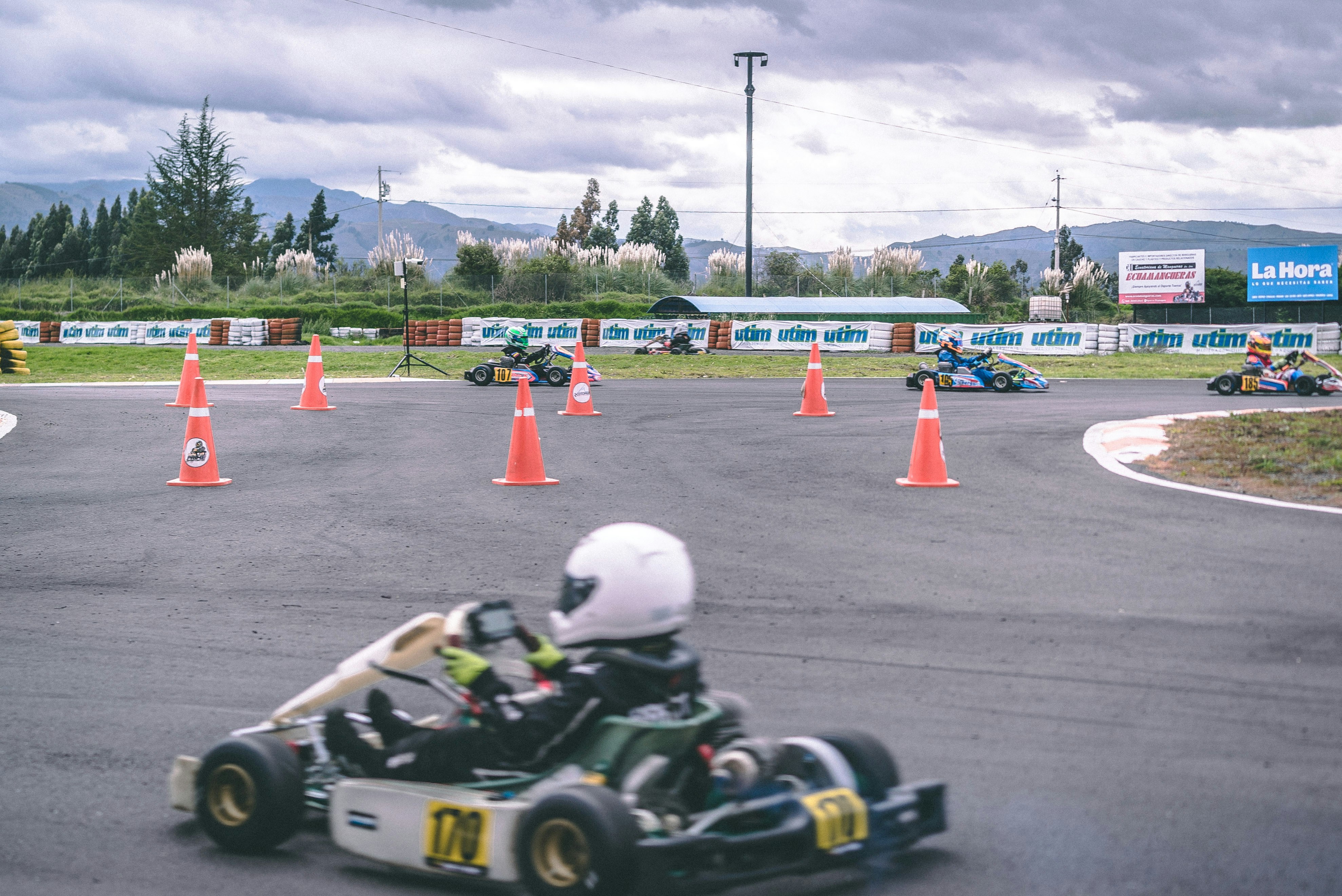 man riding go-kart near traffic cones during daytime