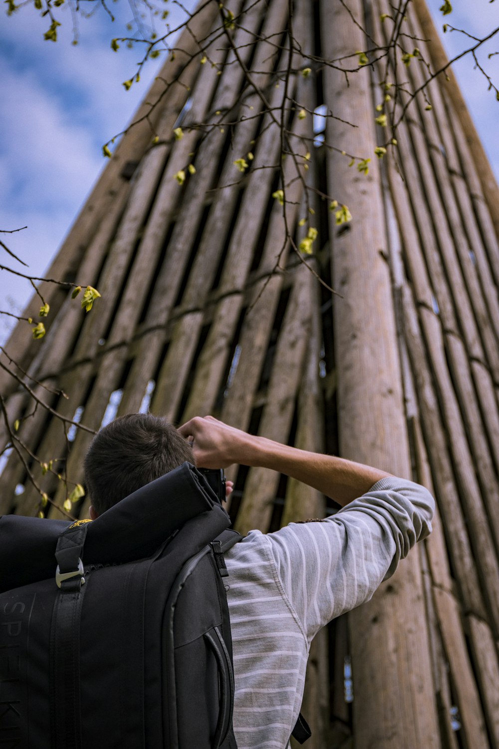 man taking picture of wooden tower