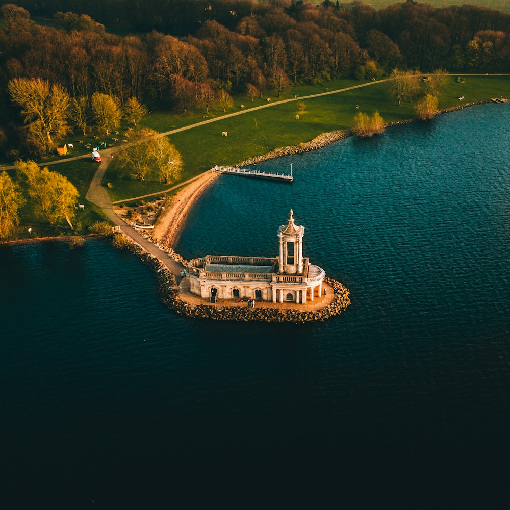 aerial view of building near trees and body of water